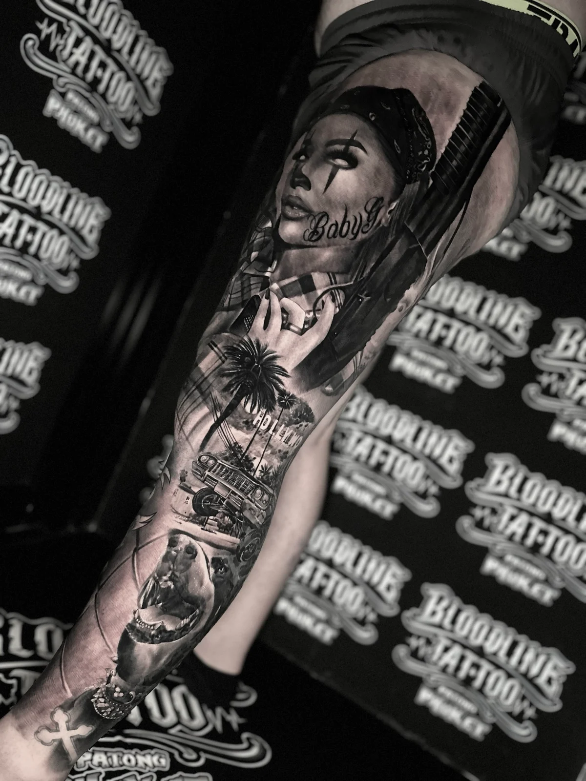 Chicano Baby Girl payasa leg sleeve with shotgun, Hollywood sign, lowrider, and pitbull at Bloodline Tattoo Phuket.