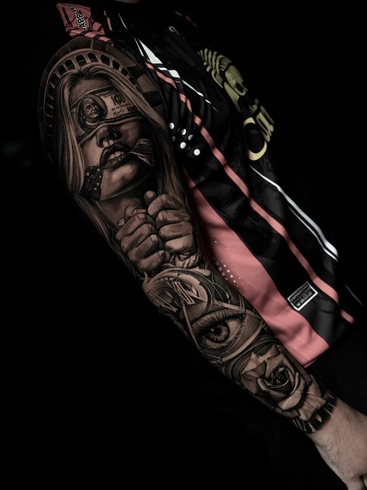 Chicano arm sleeve with Statue of Liberty portrait, money blindfold, clock, eye, and rose at Bloodline Tattoo Phuket.